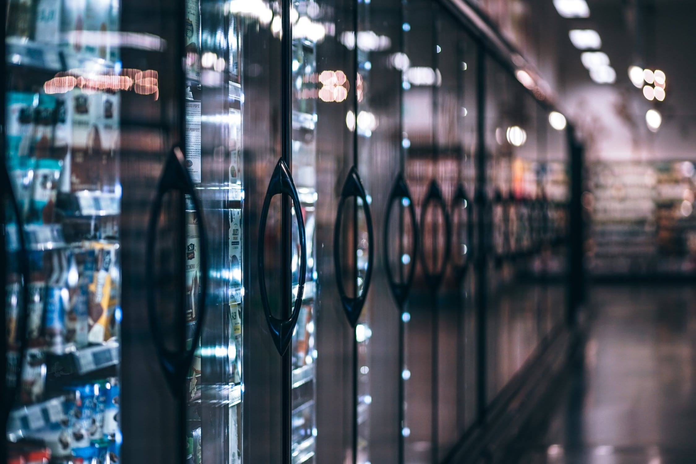 Refrigerators lined up in a grocery store.