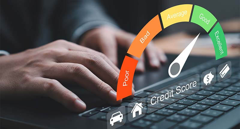 Close-up of hand typing on a laptop with a credit score gauge displayed