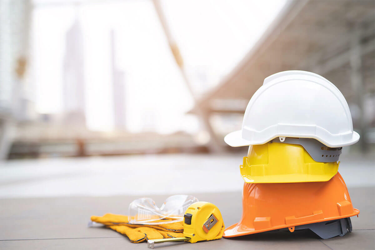 construction hats and safety glasses sitting on a paved surface