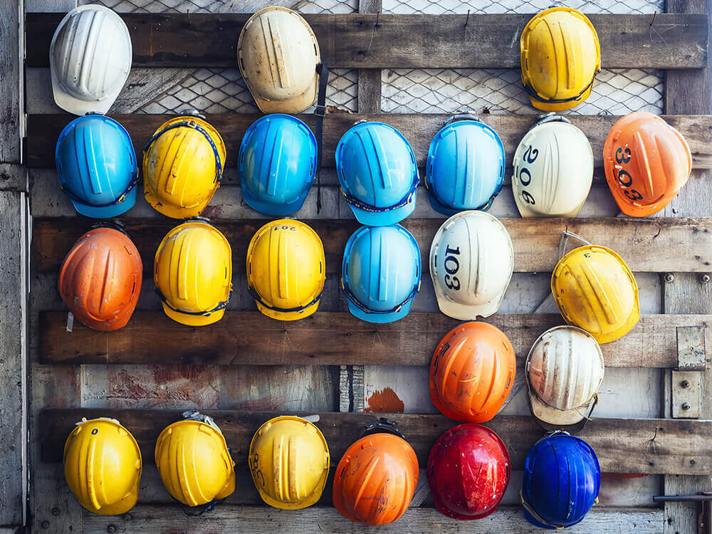 colored hard hats hanging on a wall