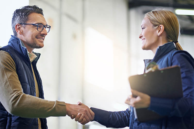 smiling new hire shaking hands with employer