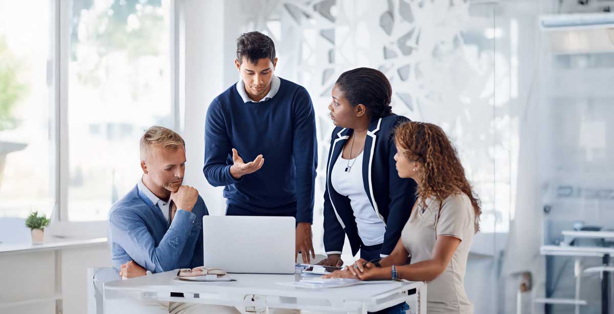Insurance representatives around a conference table looking at a laptop