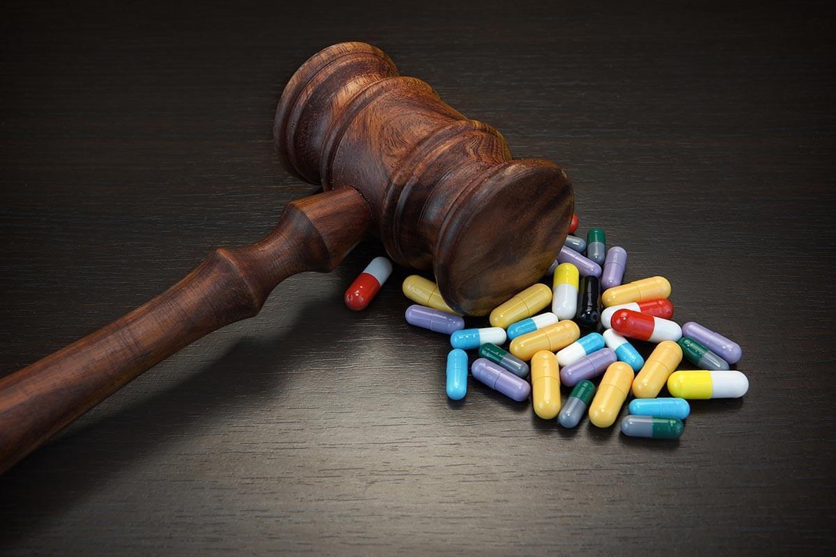 Gavel with a variety of pills on a table