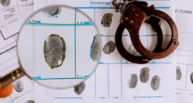 criminal record fingerprint magnifying glass and handcuffs