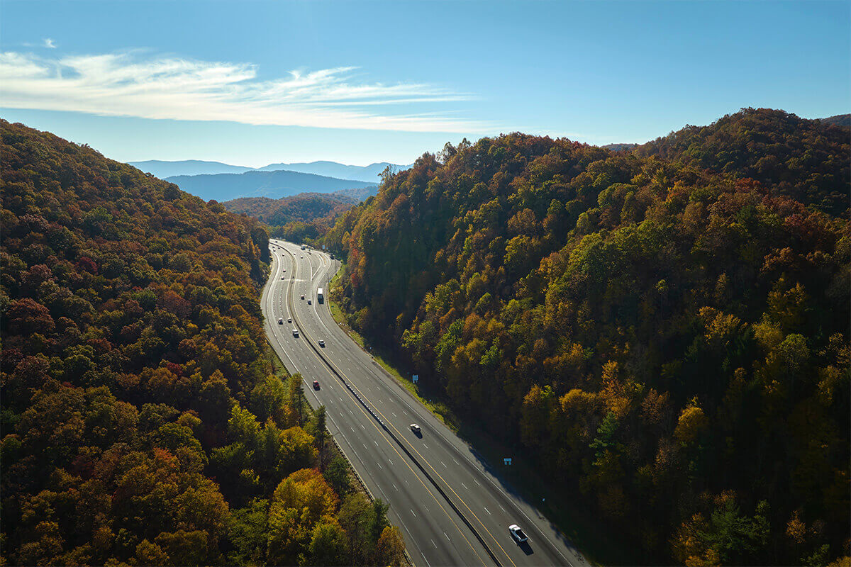trucks and cars driving on highway with skyline
