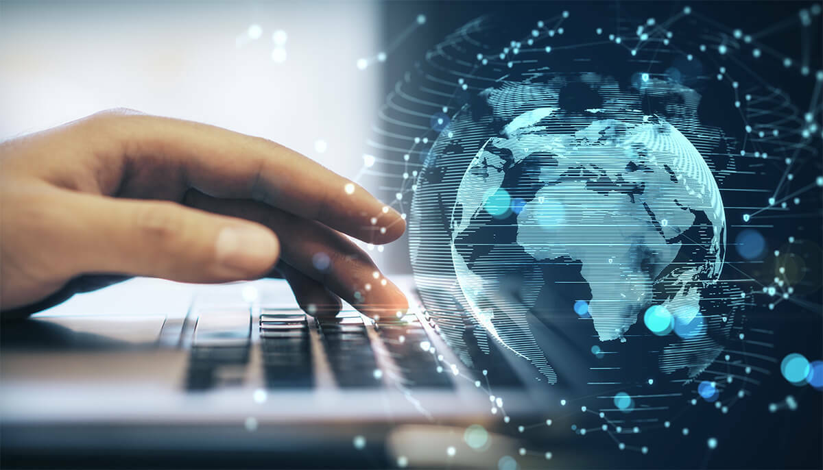 person working on a laptop with a digital globe image