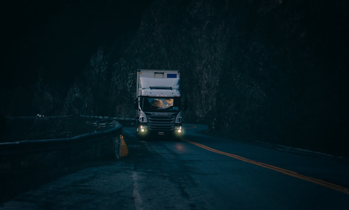 Truck driving on a dark and winding road at night