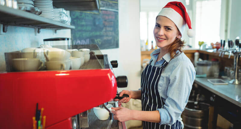 seasonal employee barista wearing santa hat
