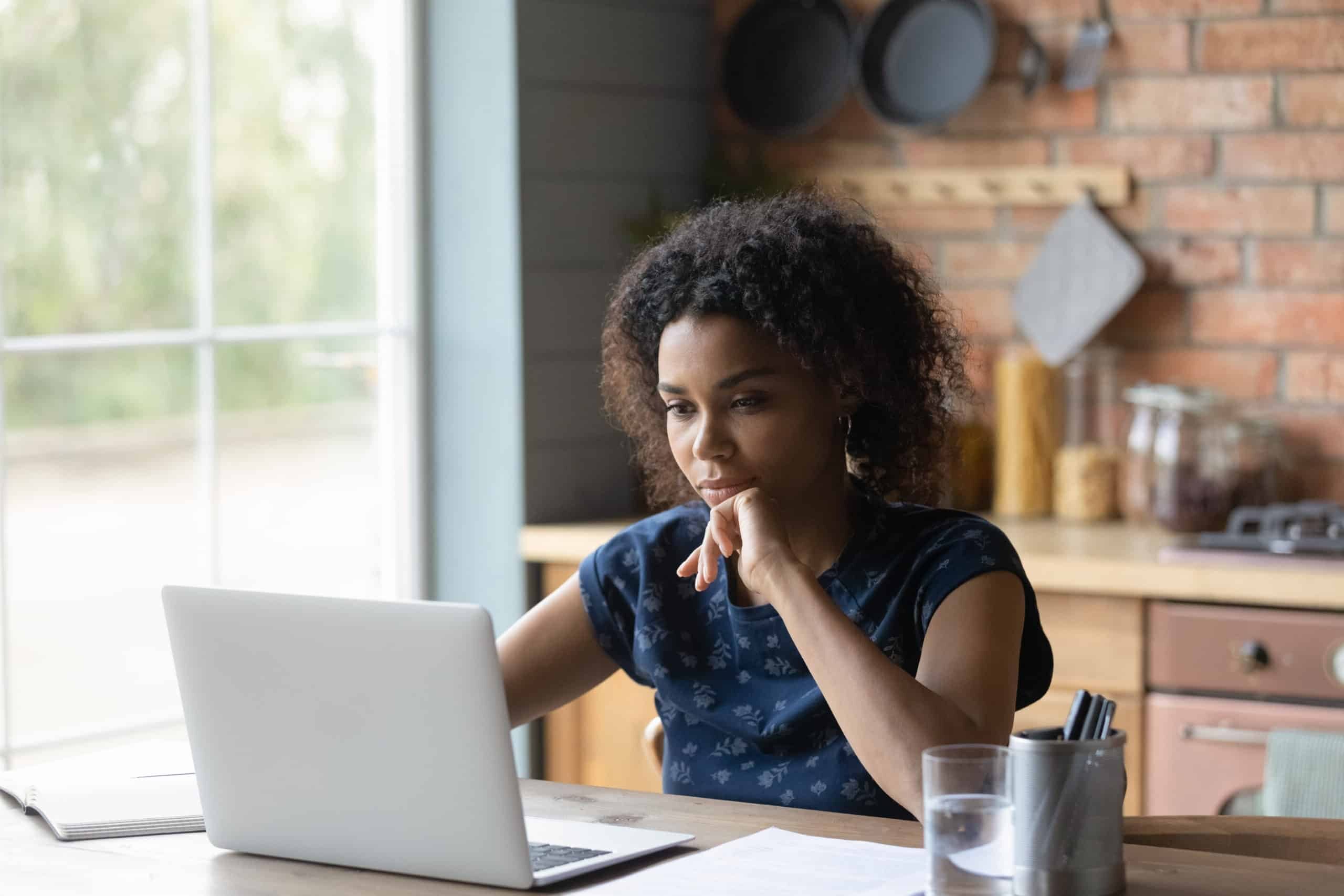 En kvinna sitter vid datorn och letar efter information om bakgrundskontroll vid en jobbansökan