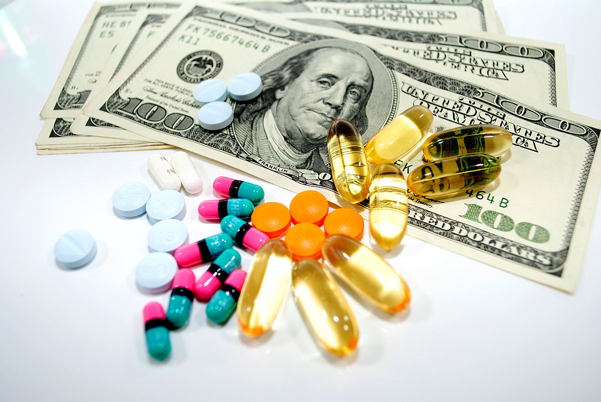 illicit pills sitting on top of a stack of money