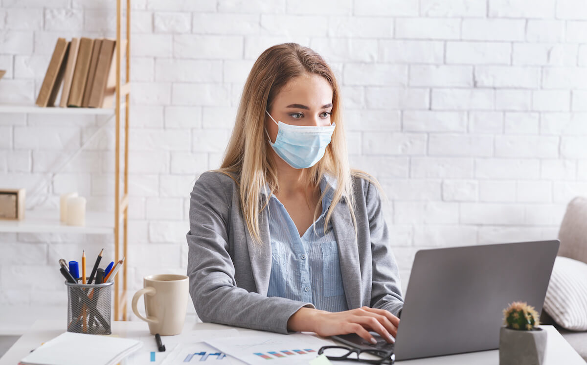 employee working on laptop with covid mask