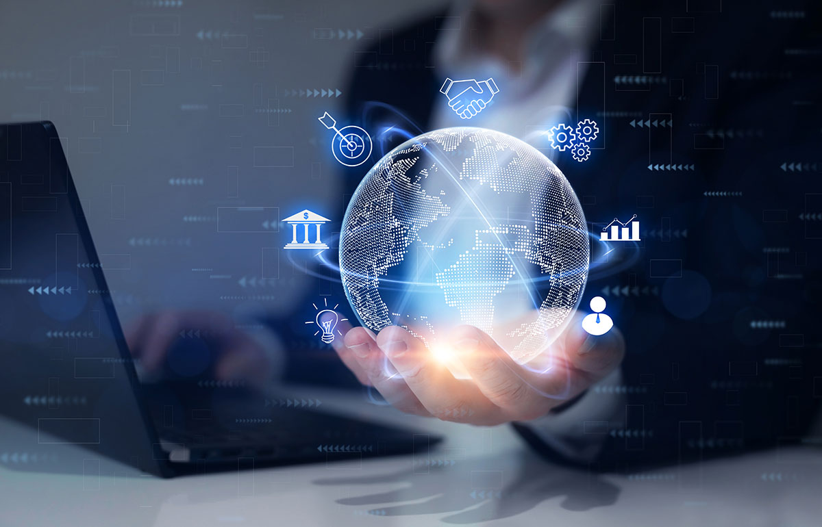 A hand holds a glowing sci-fi globe with blue icons around it, while the other operates a computer