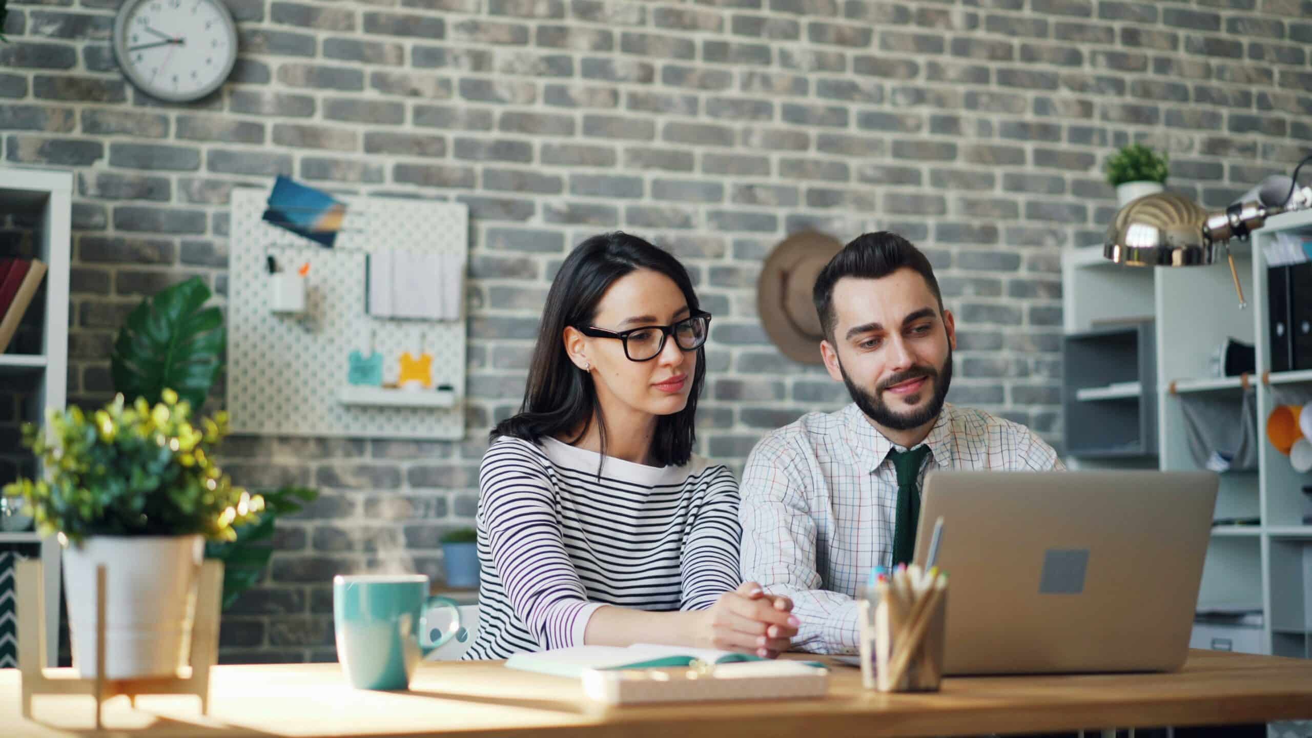 Two colleagues working together in front of the computer.