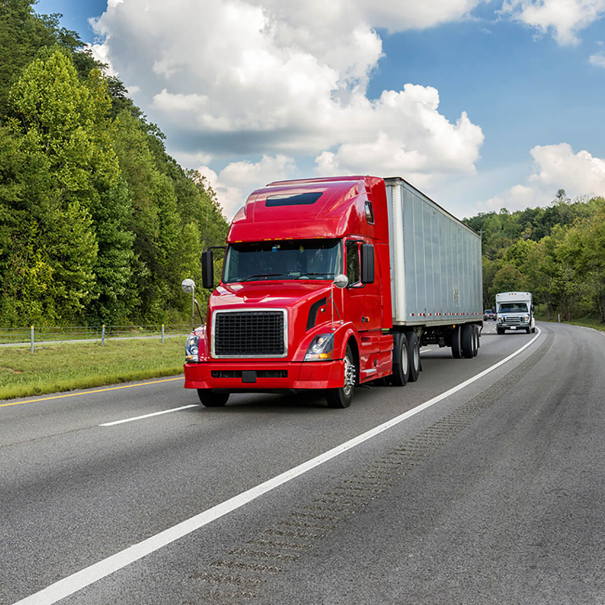 Bright red 18-wheeler truck driving on the road