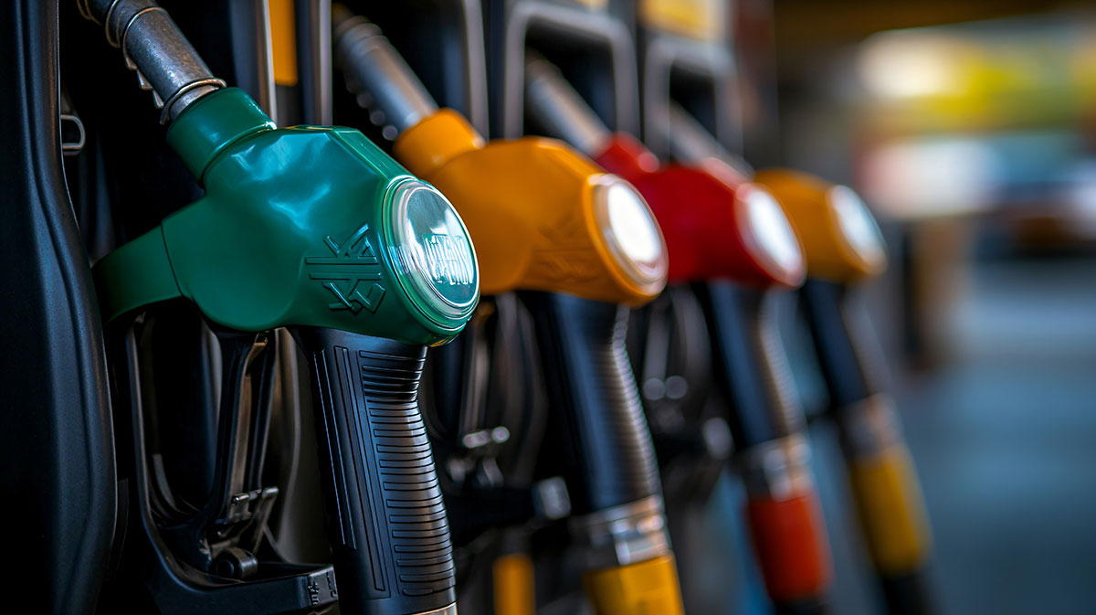 Close-up of colorful fuel pump nozzles at a gas station, in a row with different colors indicating various types of fuel. Fuel Tax Recovery