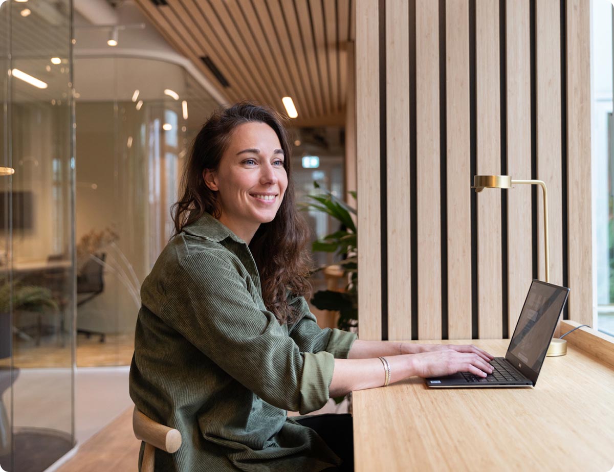 woman smiling and working on a laptop