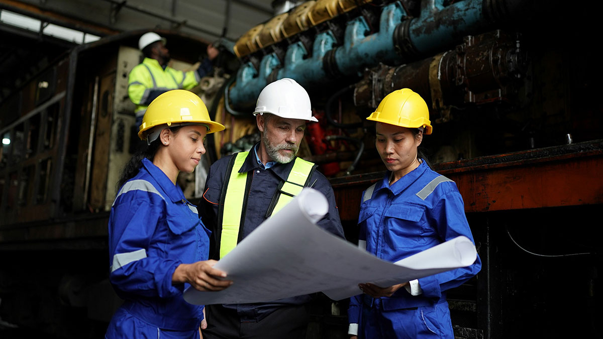 Industrial workers meeting and looking at blueprint