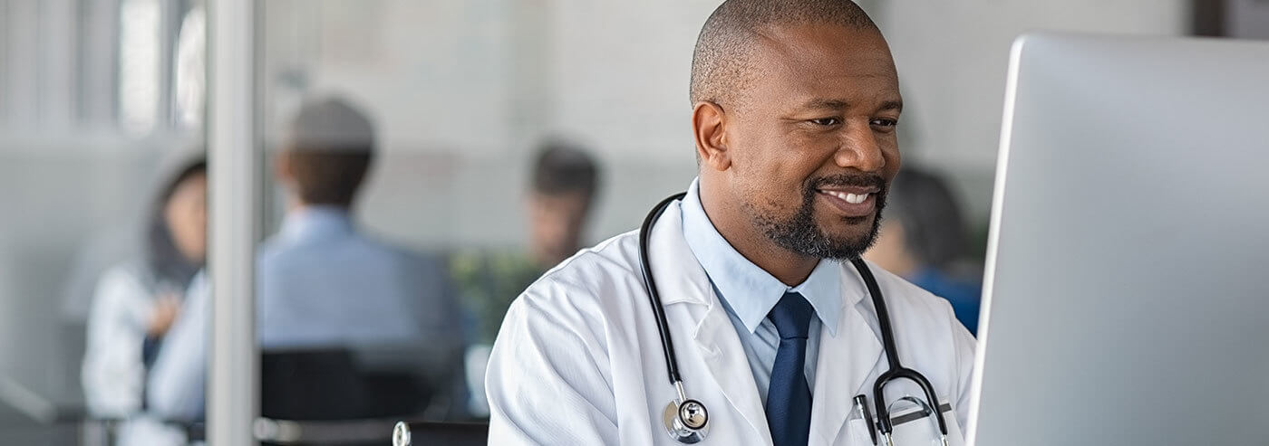 doctor working on a computer and smiling