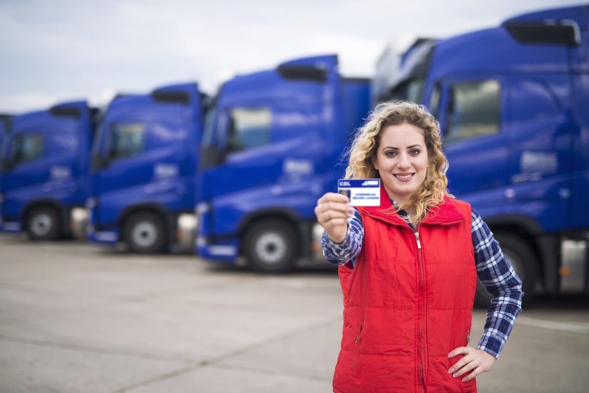 A 21 year old female truck driver holding up her CDL license