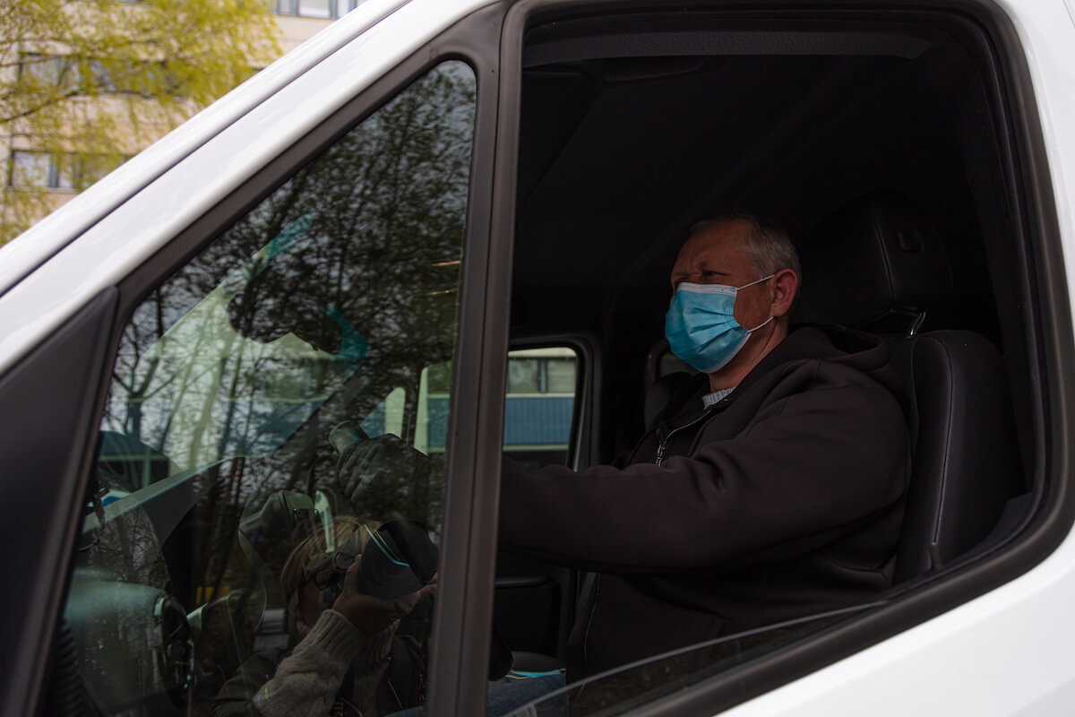 Truck driver behind the wheel wearing a medical mask