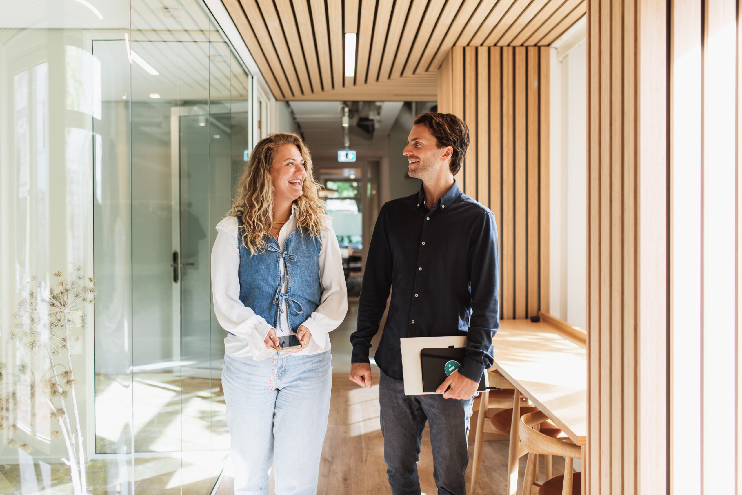 Two coworkers walking and smiling