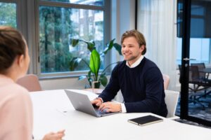 DISA worker sitting at a table using a laptop to research work experience of a job applicant