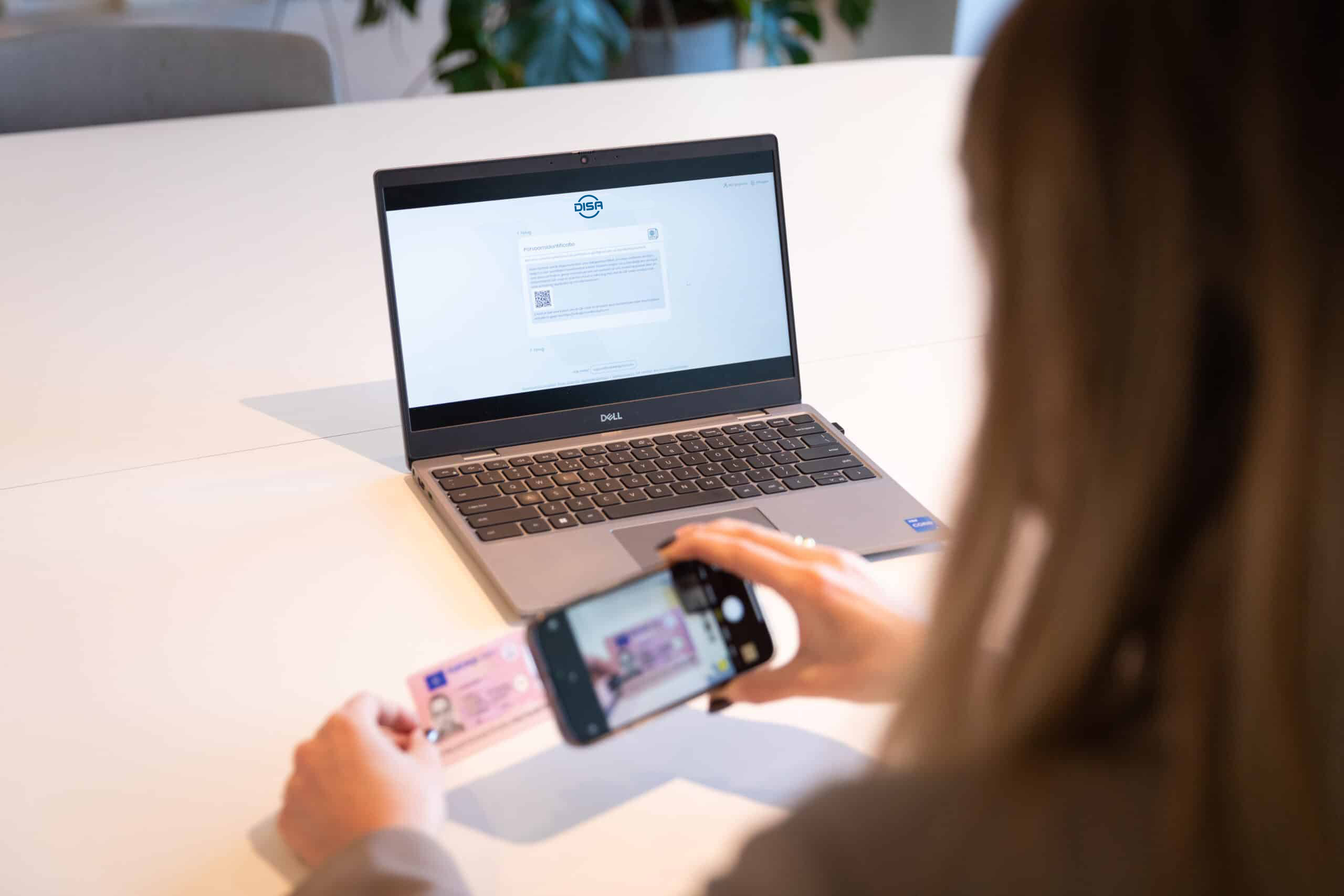 Woman taking a photo of her identification card and uploading it to a website