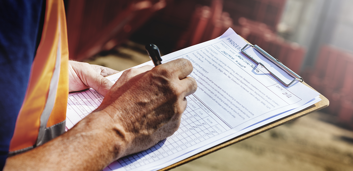 site safety inspector taking notes on a clipboard