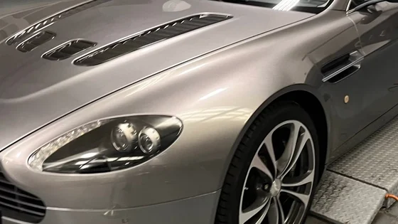An Aston Martin on a ramp in a workshop