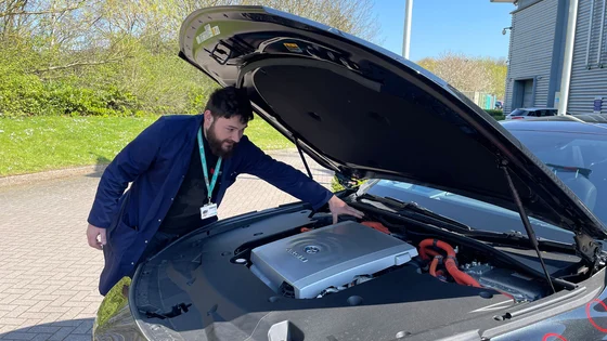 A member of staff looking at the engine of an electric car at Emtec.