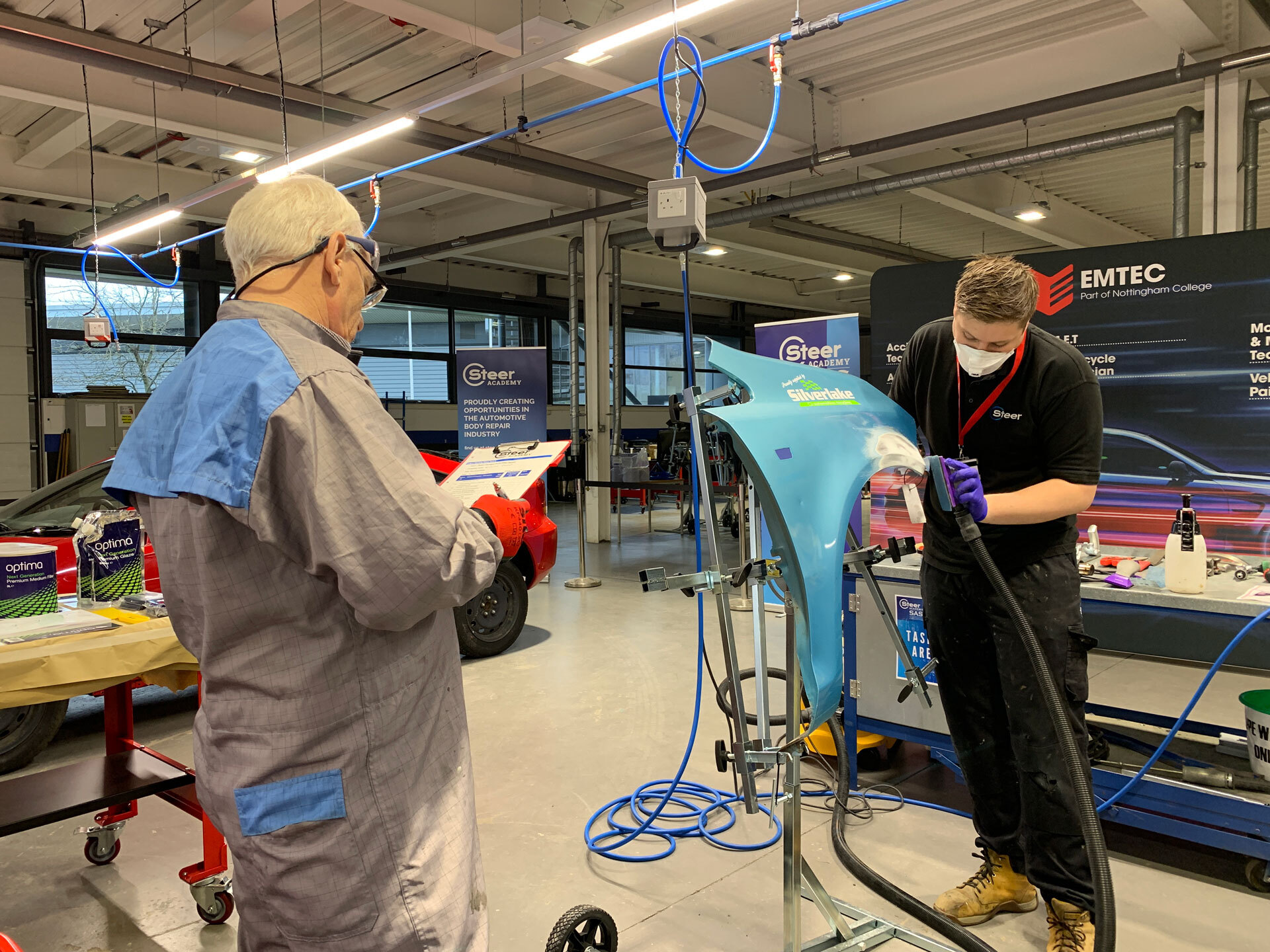 a teacher instructing an apprentice on bodywork repairs