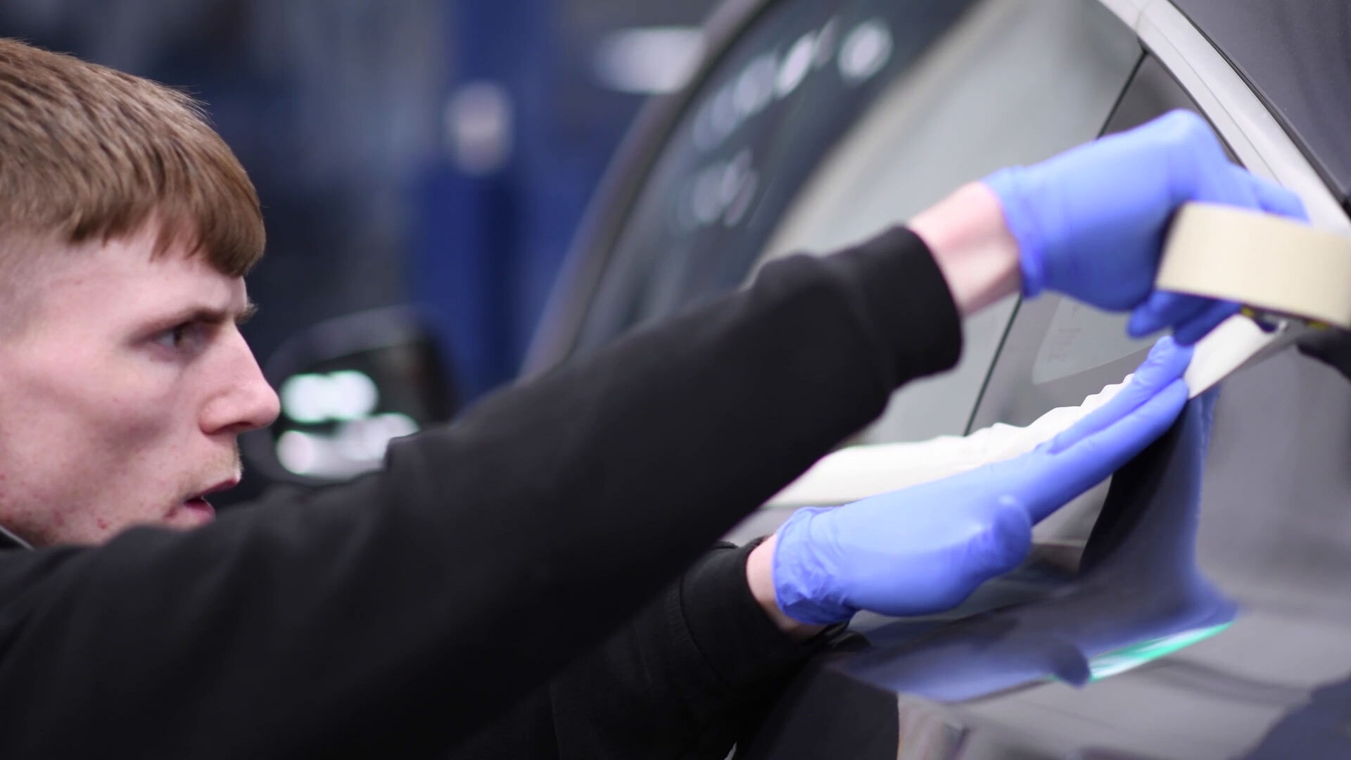 A student working on the body of car.