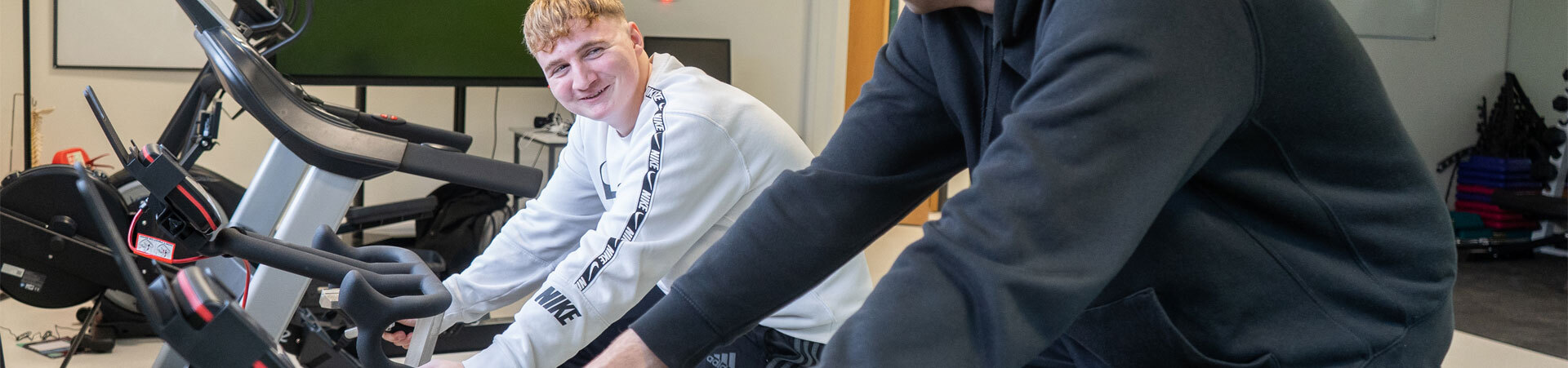 Two students using exercise bikes