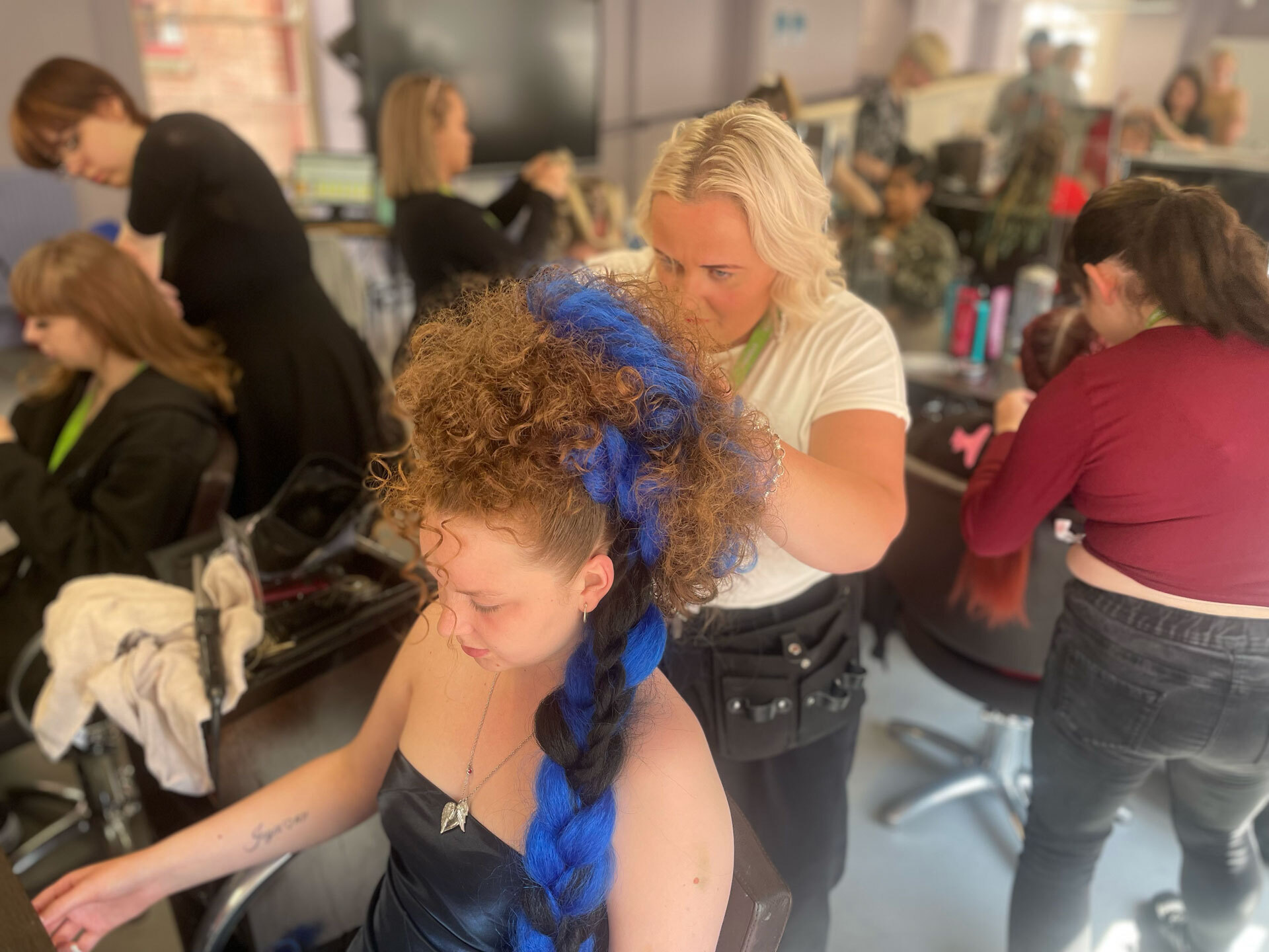 A student styling someone's hair in the hair salon