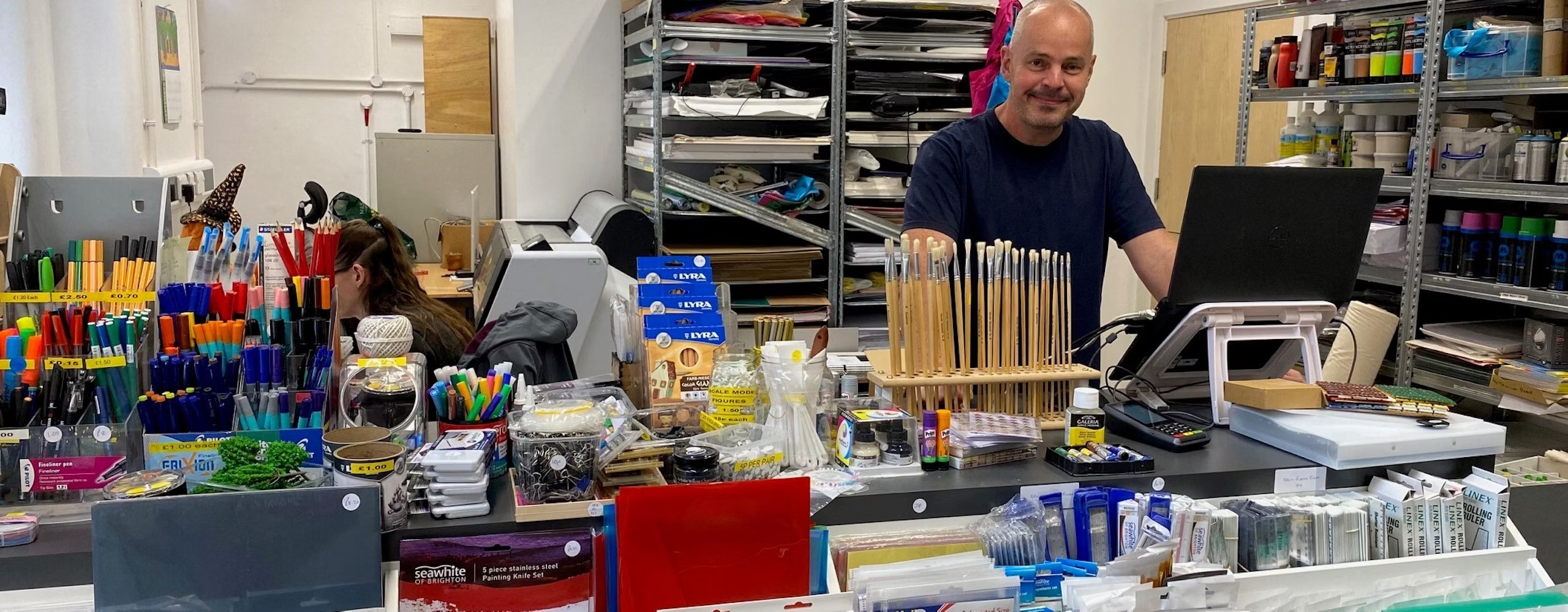 Inside the art shop, showing the front counter with art materials on display