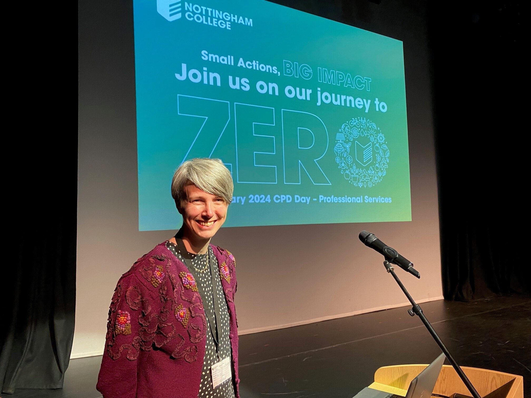 An external speaker in the theatre at the City Hub standing in front of a screen saying Join us on our journey to Zero