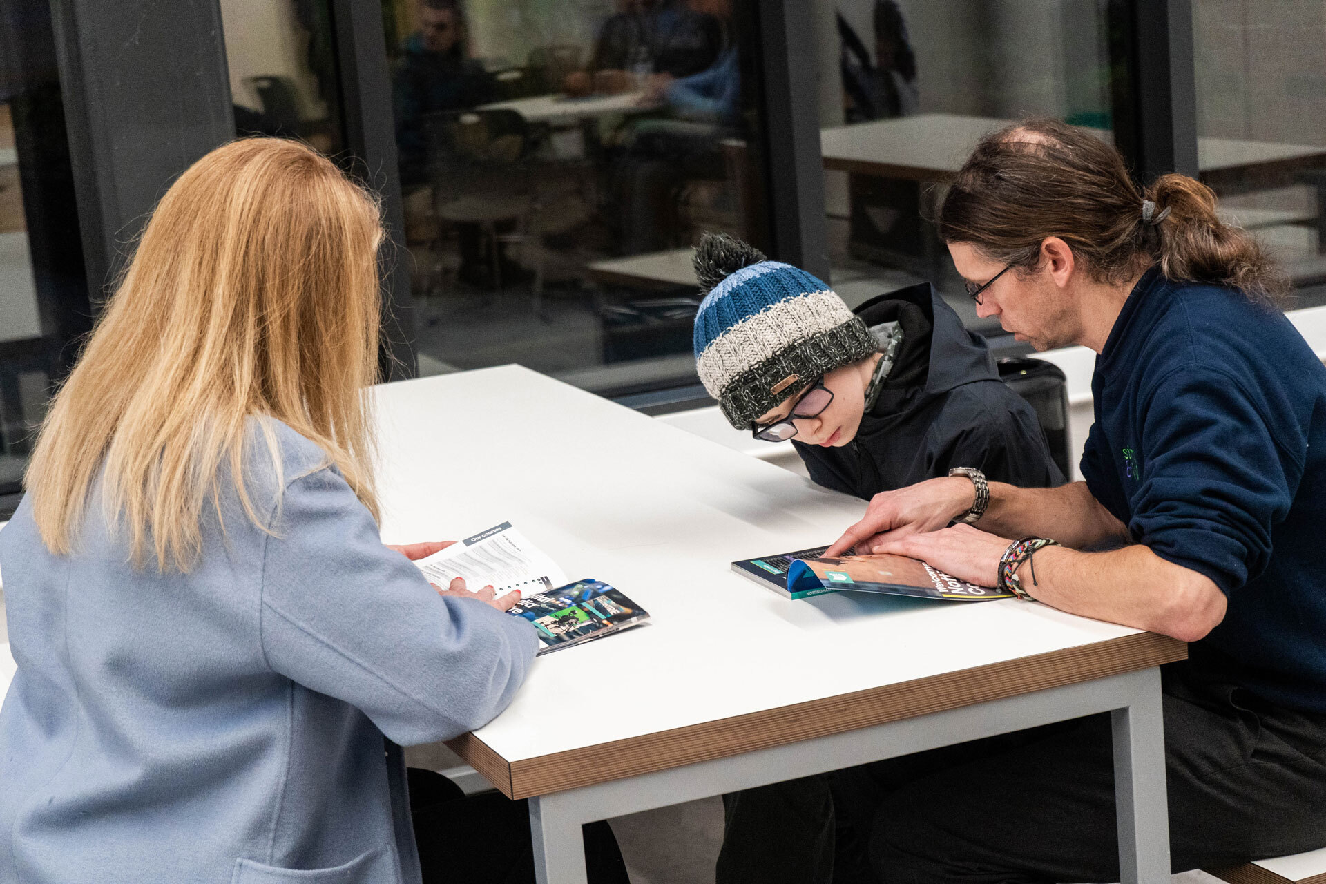A group of young people sitting around a table looking at a leaflet.