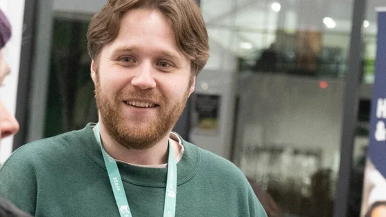 A member of staff taking to two mature students.