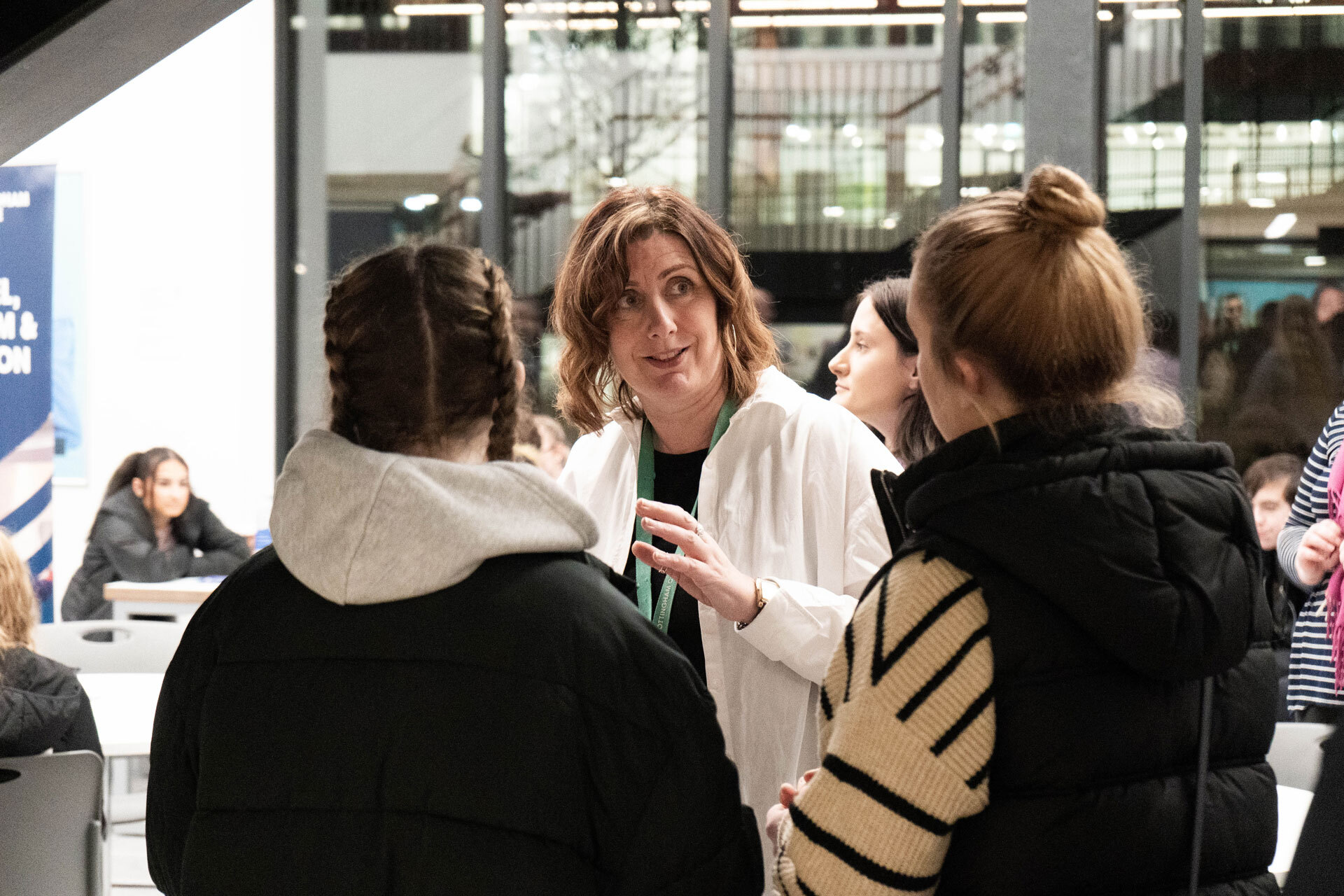 A member of staff explaining something to students an an Open Evening
