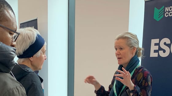 Adult students talking to a staff member about course information.