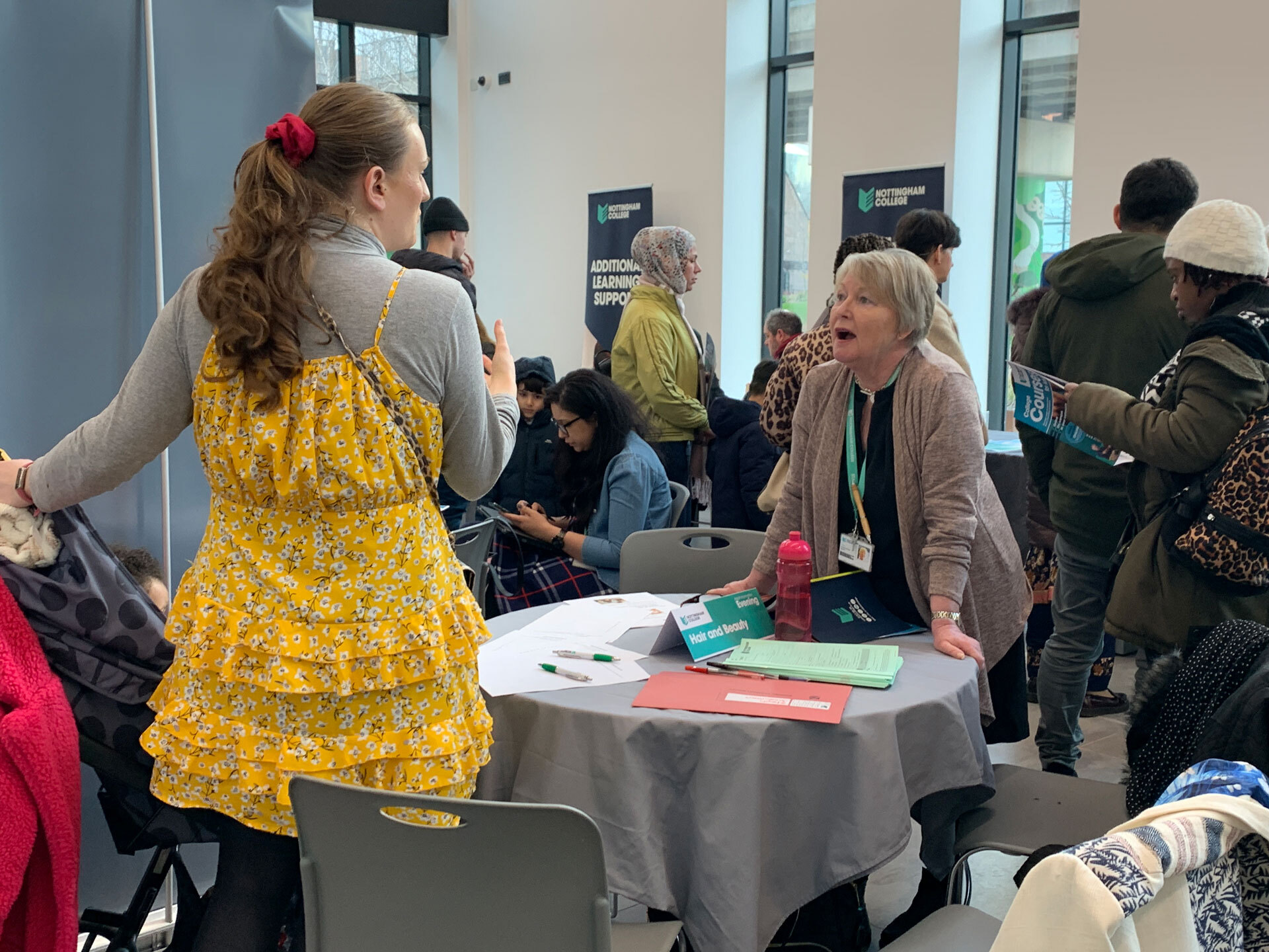 A member of staff talking to a visitor at the City Hub.