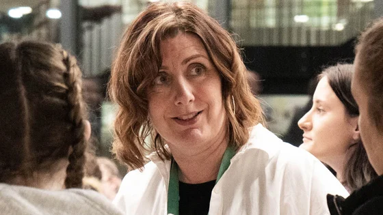 A member of staff talking to students at an open evening