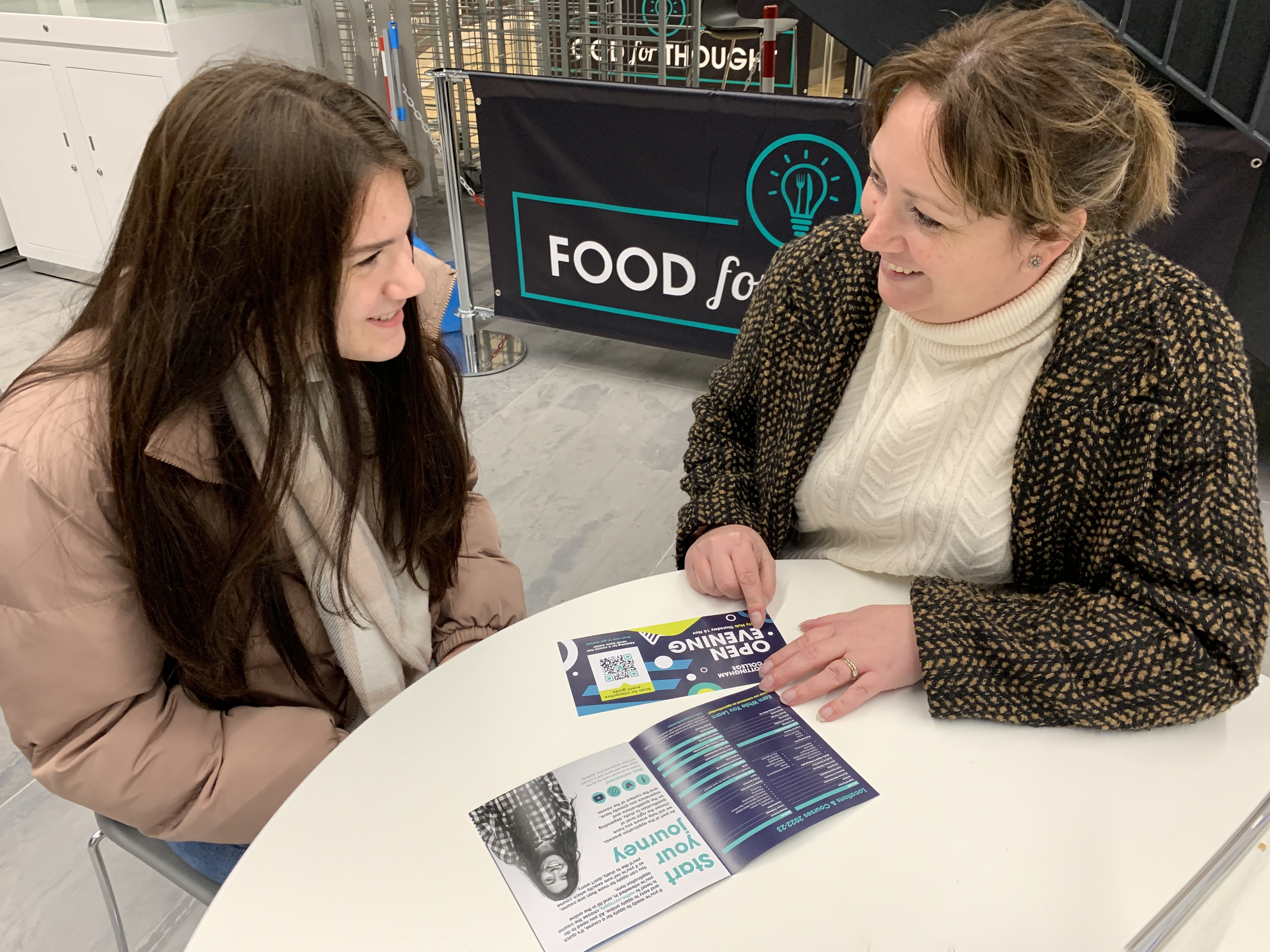 A parent and a student sitting at a table at an Open Evening