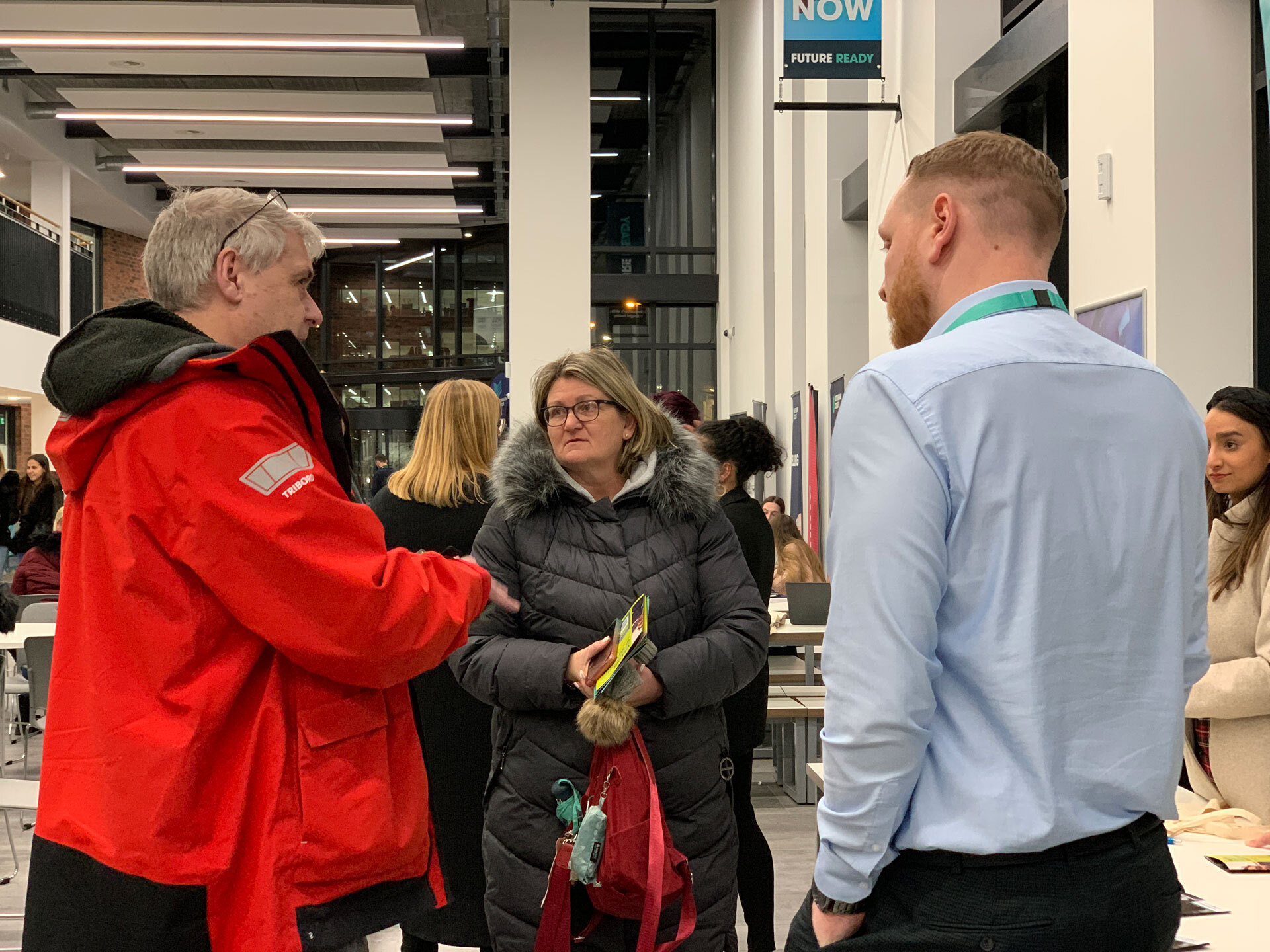 A member of staff talking to visiting at an open event at the City Hub.