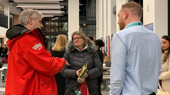A member of staff talking to visiting at an open event at the City Hub.