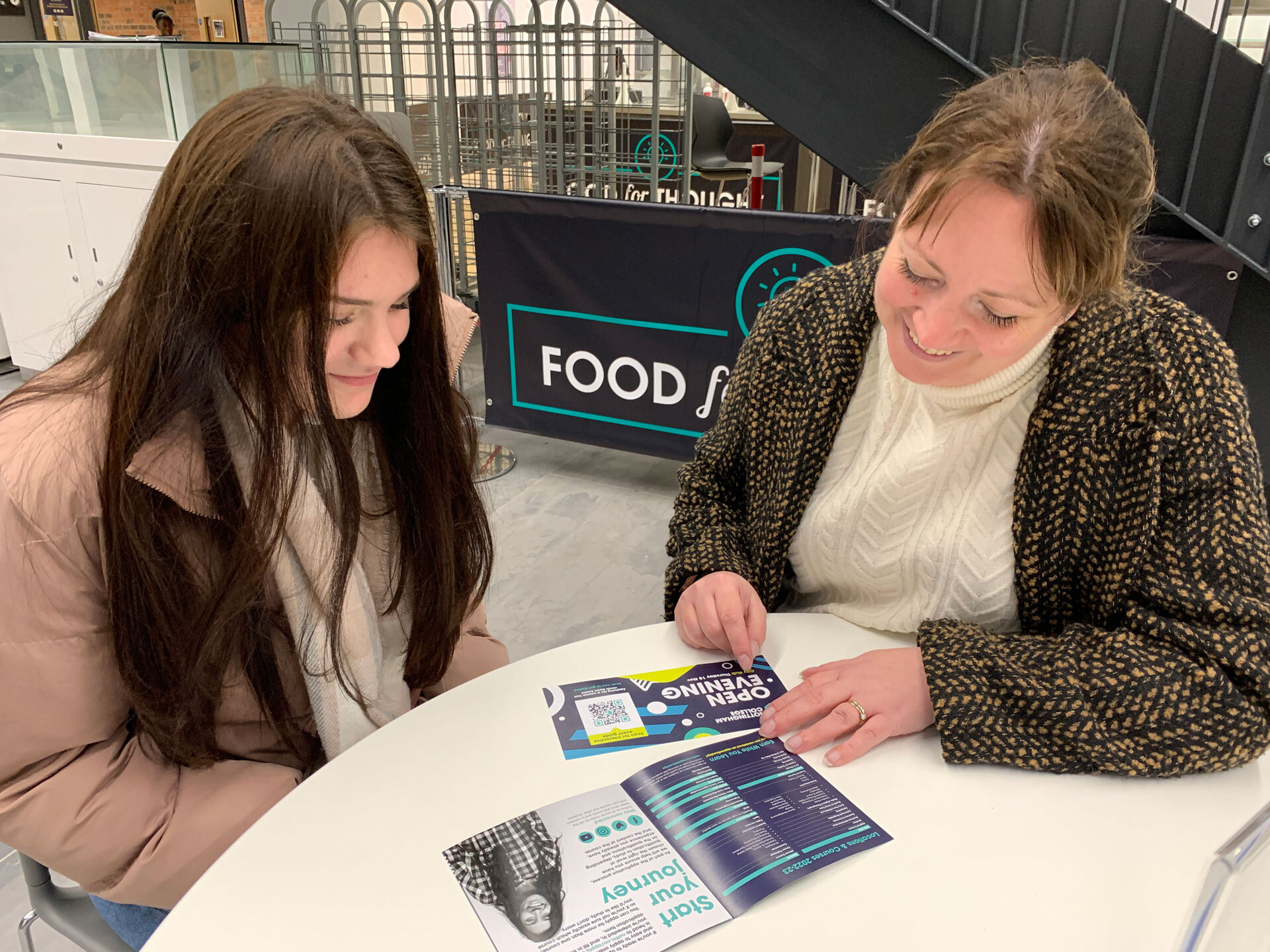 A lecturer and student talking in the canteen at the City Hub