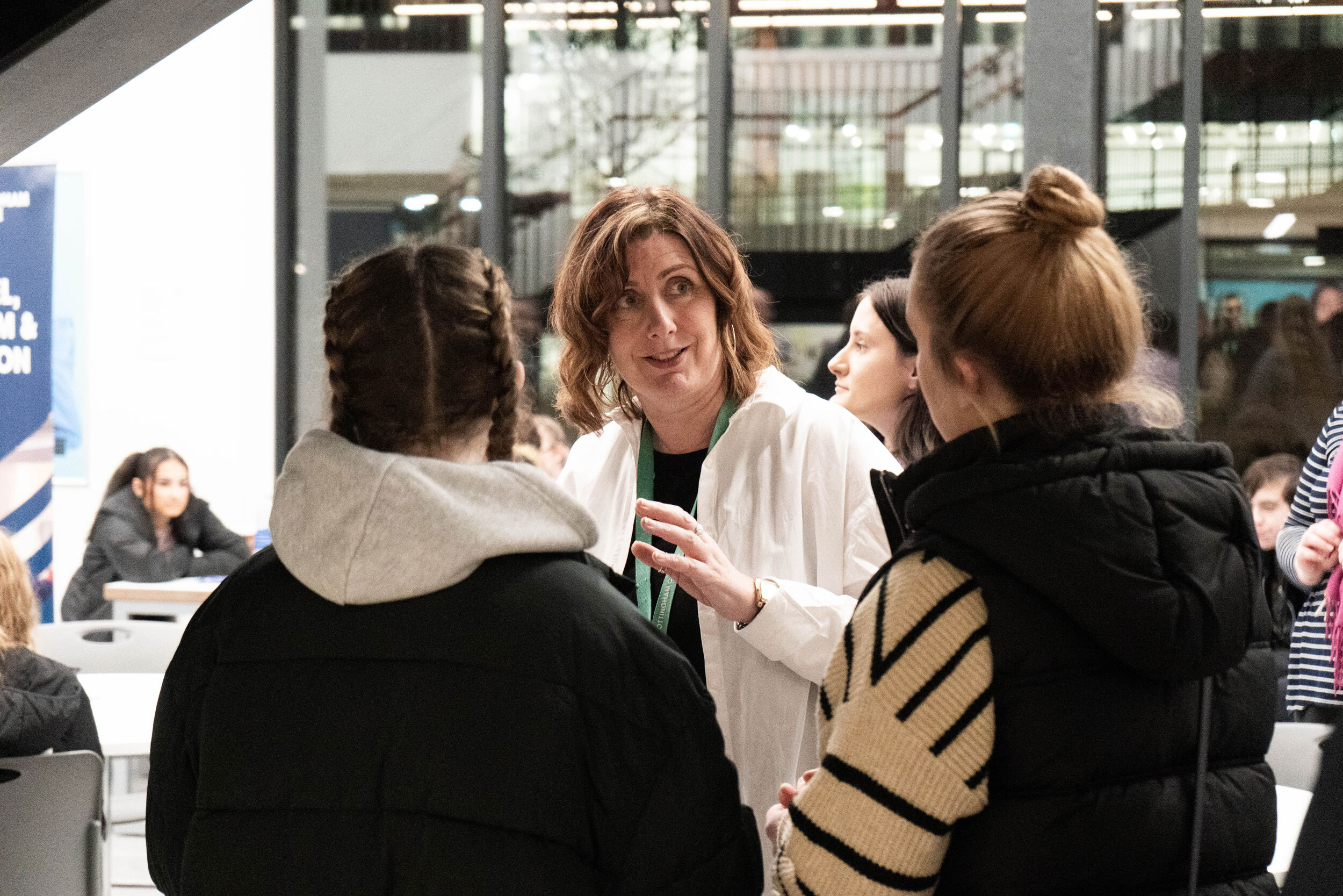 A group of students talking to a member of staff at an open Evening at the City Hub