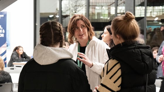A group of students talking to a member of staff at an open Evening at the City Hub