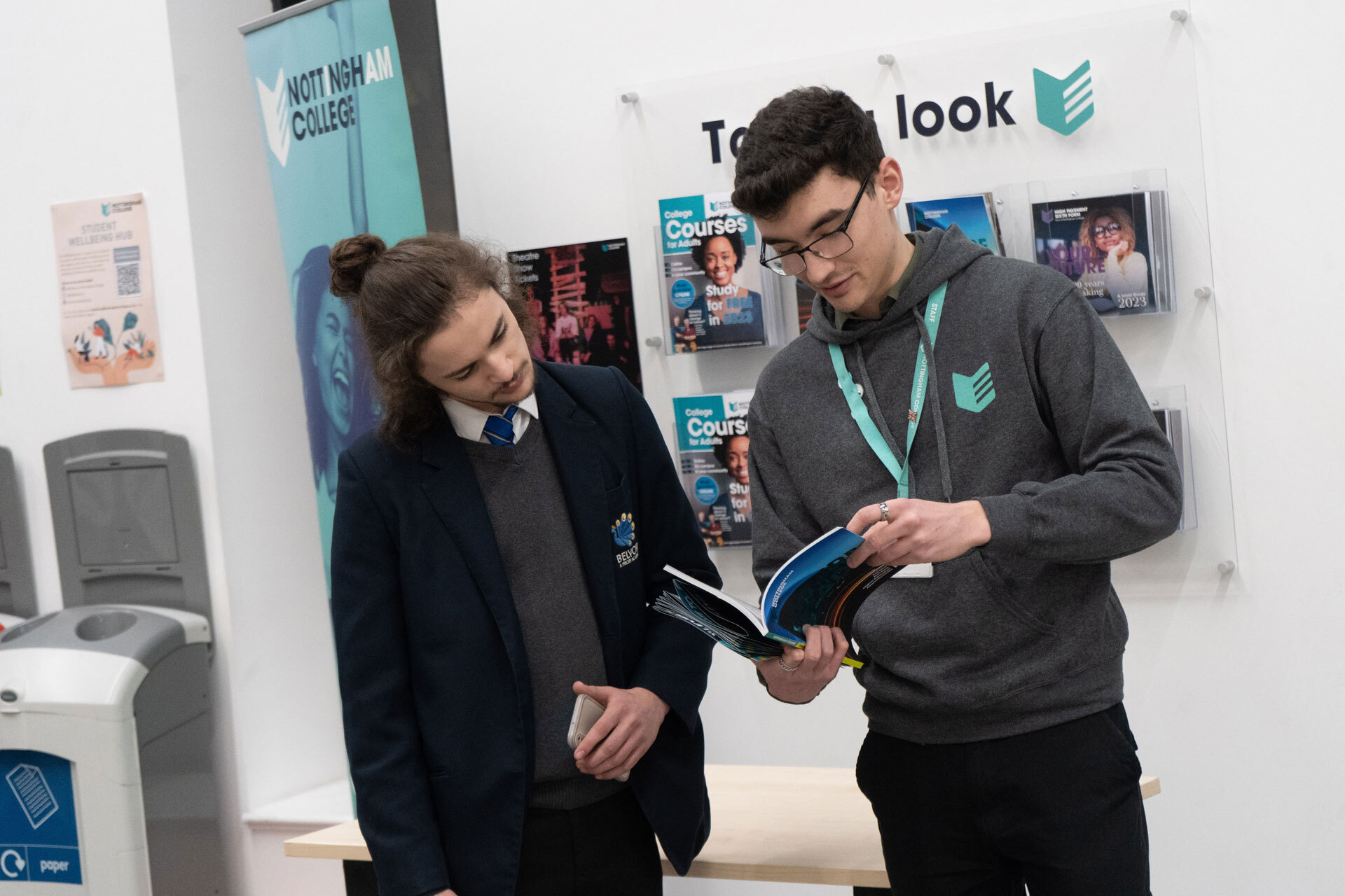 A member of staff talking to a prospective student at an open evening at the City Hub.