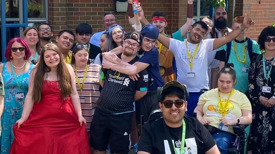 Supported Learning students with staff standing outside.